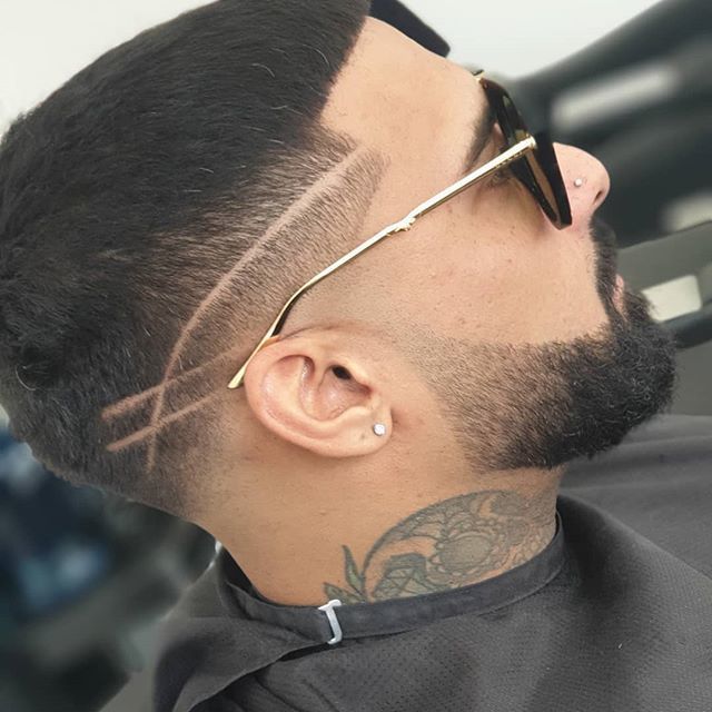 Skin fade with crossed line design and beard